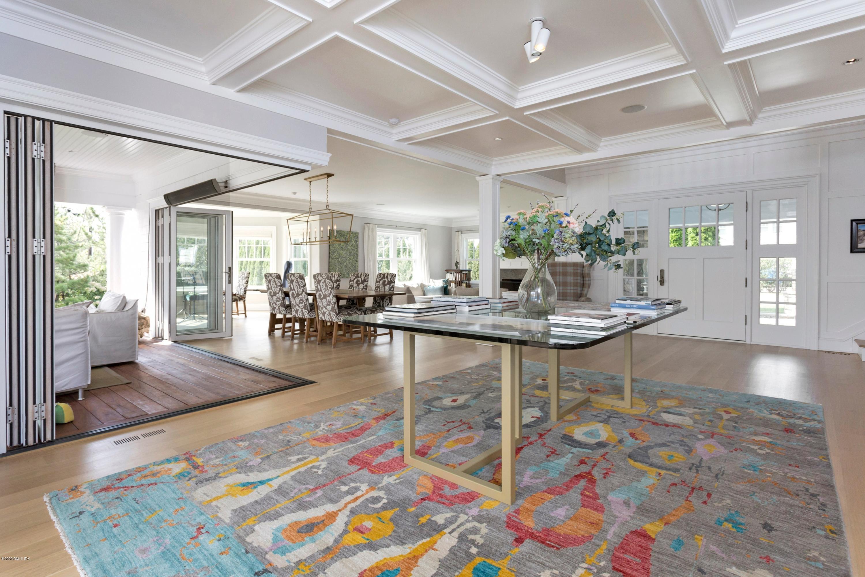 186 Shore Road Old Greenwich, CT 06870 - Photo 6 of 37 a living room with dining table furniture and a chandelier