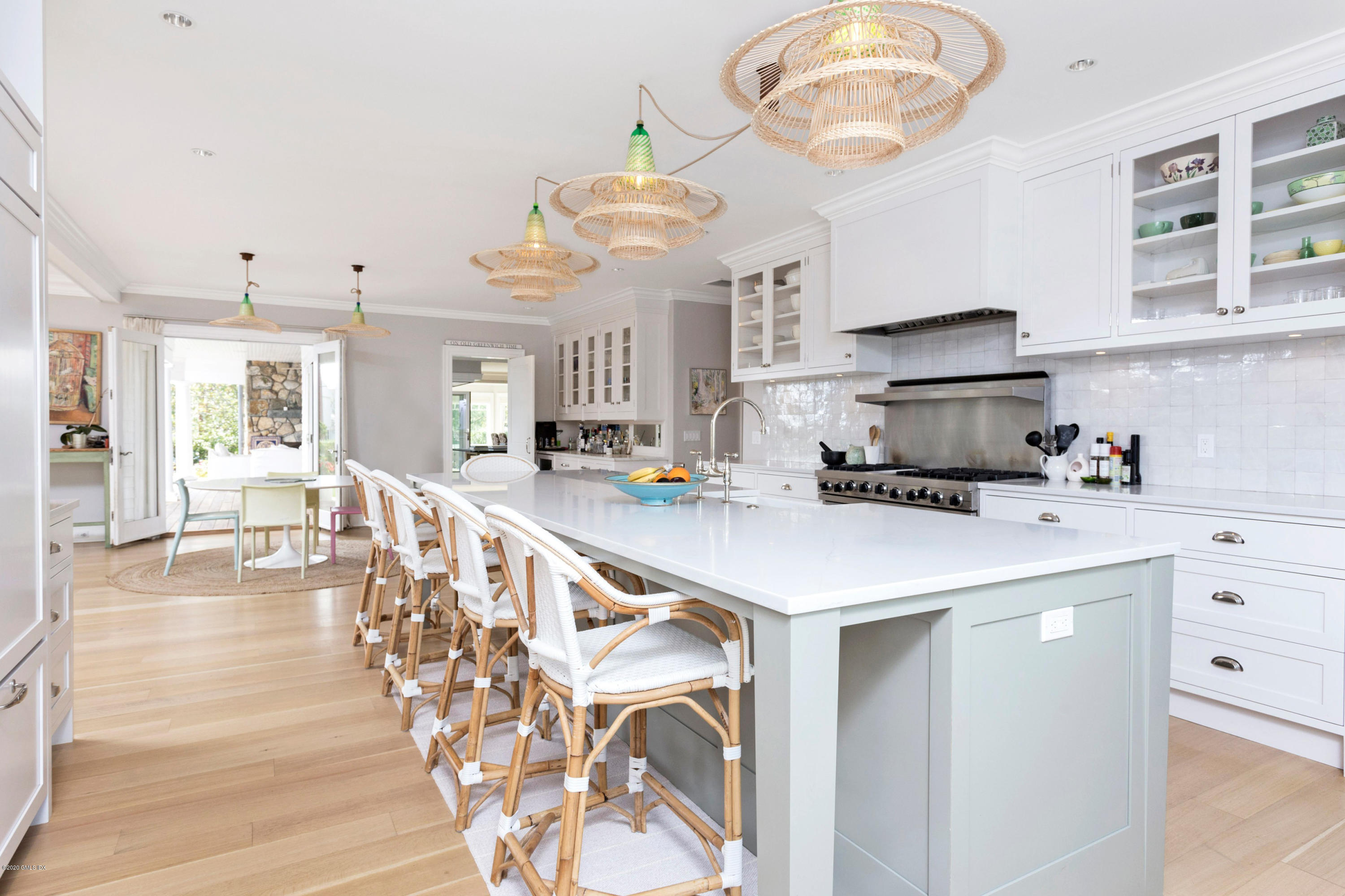 186 Shore Road Old Greenwich, CT 06870 - Photo 10 of 37 a very nice looking kitchen with granite countertop a stove a sink a dining table and chairs with wooden floor