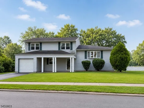 a front view of a house with a garden and yard