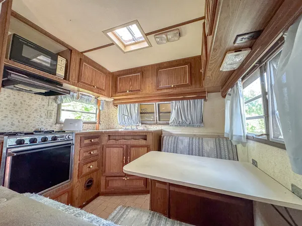 a kitchen with stainless steel appliances granite countertop a stove a sink dishwasher and white cabinets with wooden floor