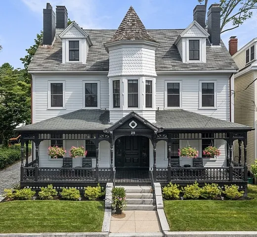 a front view of a residential apartment building with a yard and potted plants