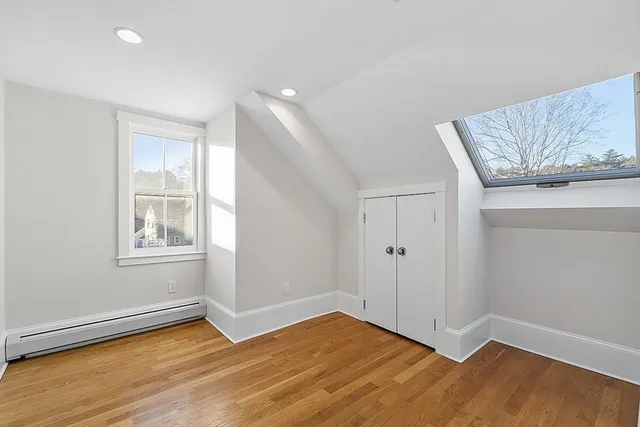 an empty room with wooden floor and cabinet