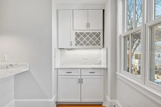 a view of a kitchen with dishwasher and white cabinets with wooden floor