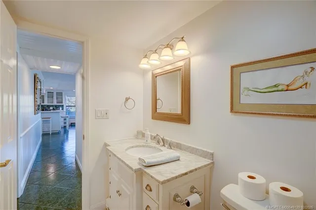 a bathroom with a granite countertop sink toilet and a mirror