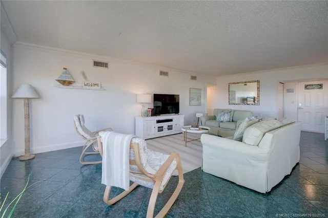 a living room with furniture a flat screen tv and a table