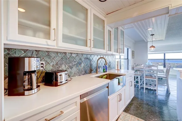 a kitchen with a sink a stove and chairs
