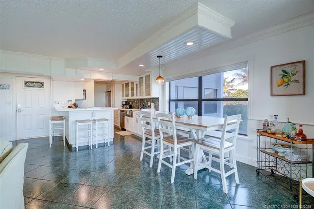 a kitchen with stainless steel appliances kitchen island granite countertop a dining table chairs and view of living room