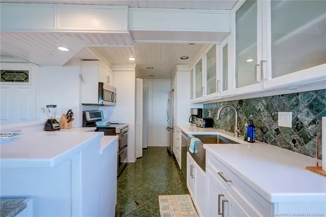 a kitchen that has a sink and a stove in it