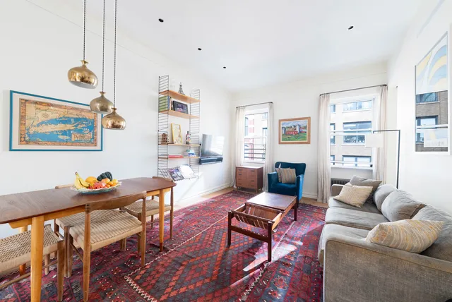 a living room with furniture a rug and a bookshelf