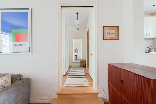 a hallway with painting and a potted plant