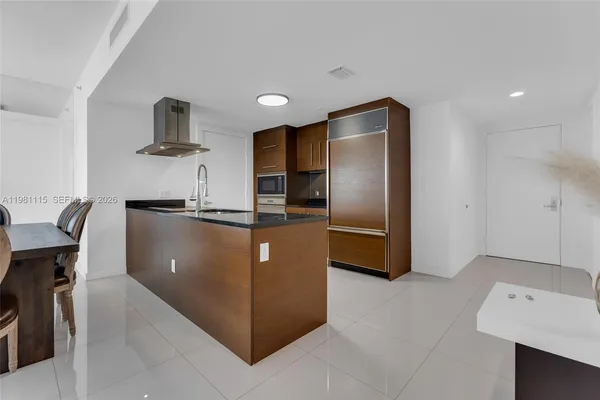 a kitchen with stainless steel appliances granite countertop a refrigerator and a sink