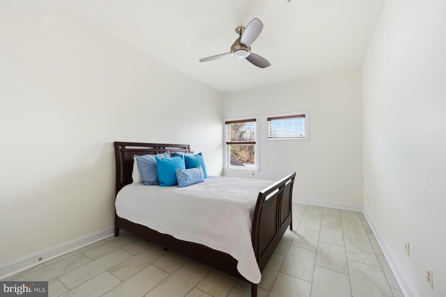 202 Muir Street, Unit 202 Cambridge, MD 21613 - Photo 18 of 54 a bedroom with a bed and a painting on the wall