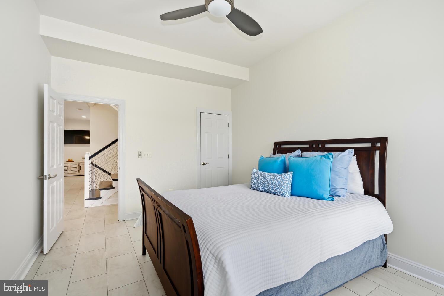 202 Muir Street, Unit 202 Cambridge, MD 21613 - Photo 19 of 54 a bedroom with a bed and a chandelier