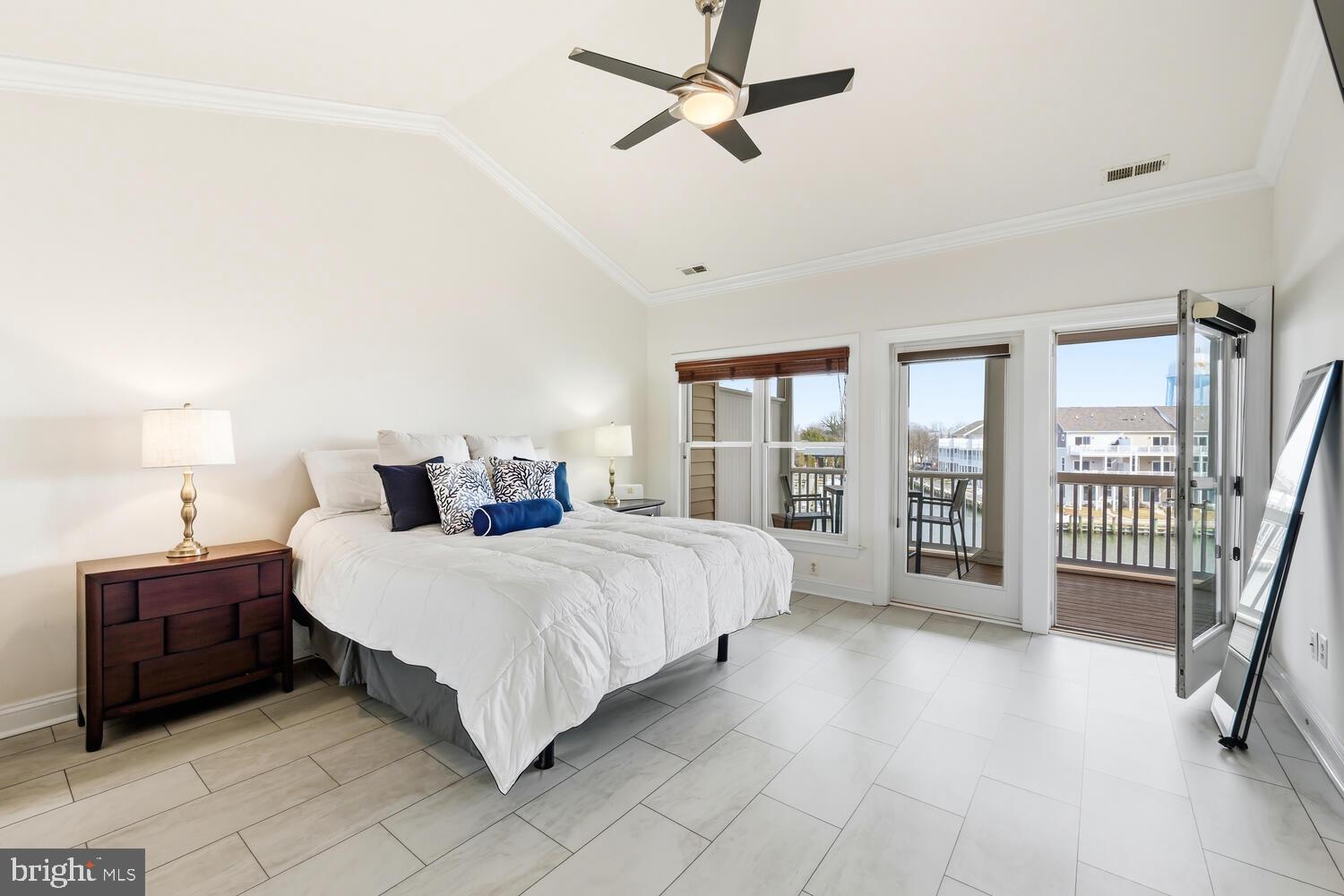 202 Muir Street, Unit 202 Cambridge, MD 21613 - Photo 24 of 54 a spacious bedroom with a bed a dresser and a chandelier
