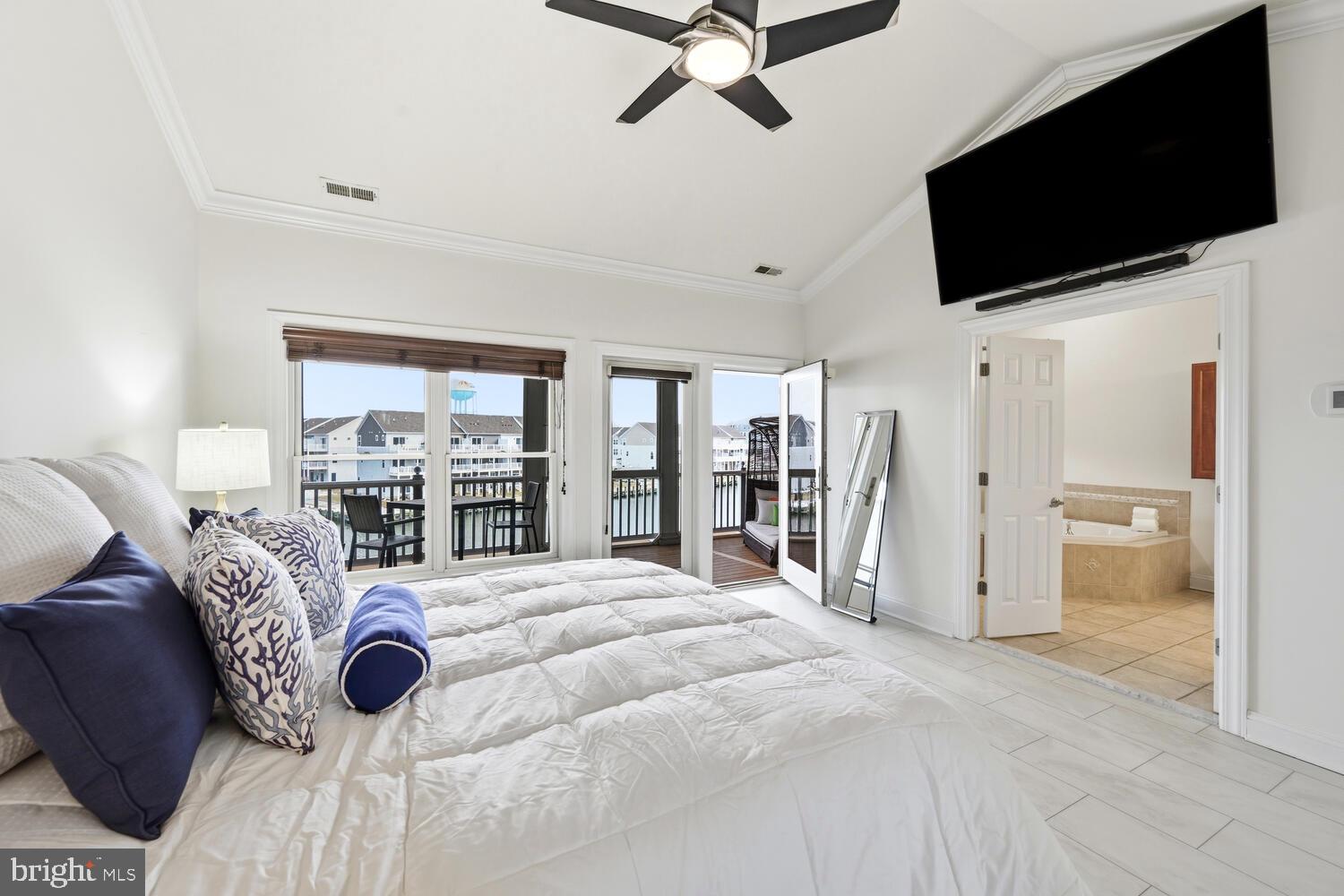 202 Muir Street, Unit 202 Cambridge, MD 21613 - Photo 25 of 54 a bed room with a bed a television and a large window