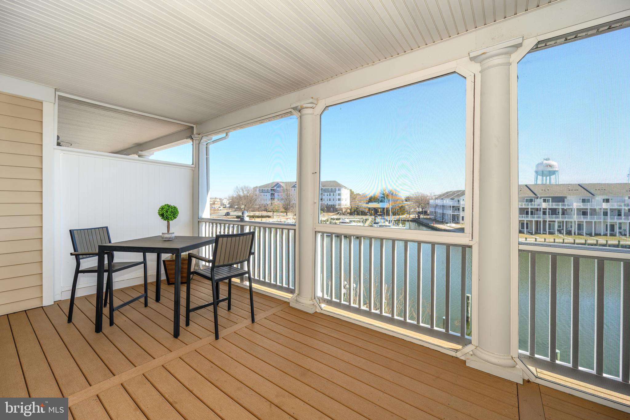 202 Muir Street, Unit 202 Cambridge, MD 21613 - Photo 29 of 54 a view of a roof deck with table and chairs with wooden floor and fence