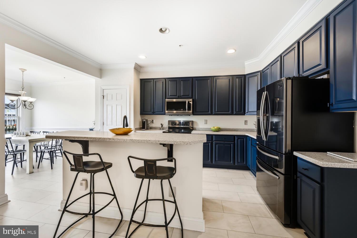 202 Muir Street, Unit 202 Cambridge, MD 21613 - Photo 9 of 54 a kitchen with granite countertop a refrigerator and a stove top oven