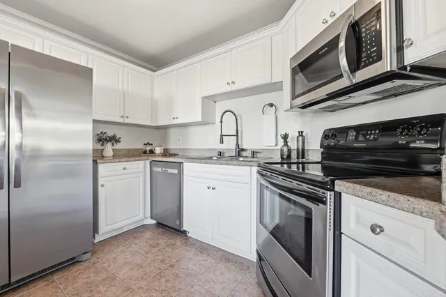 a kitchen with cabinets stainless steel appliances and a sink