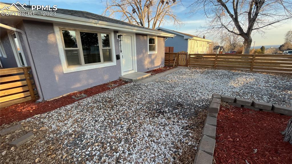 1219 Prairie Road Colorado Springs, CO 80909 - Photo 2 of 16 a front view of a house with a yard