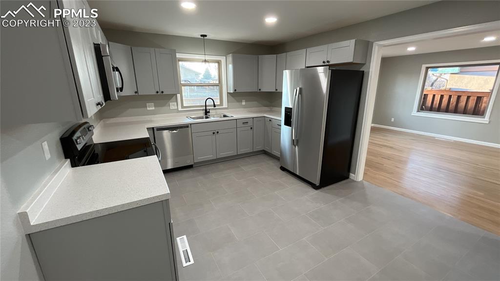 1219 Prairie Road Colorado Springs, CO 80909 - Photo 8 of 16 a kitchen with a refrigerator a sink and a stove top oven