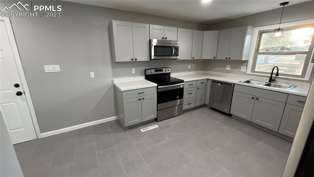 1219 Prairie Road Colorado Springs, CO 80909 - Photo 9 of 16 a kitchen with sink a microwave and cabinets