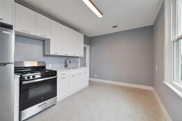 a kitchen with a sink cabinets and a window