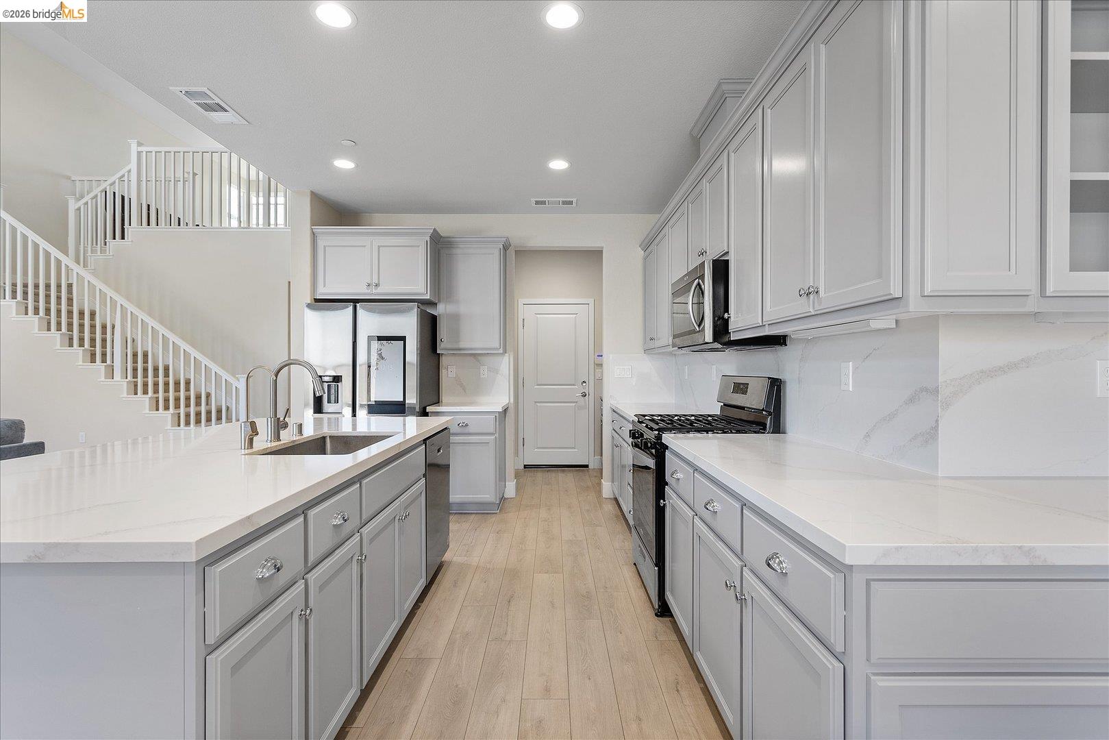 5601 Ridgepoint Way Antioch, CA 94531 - Photo 15 of 59 Modern kitchen featuring light wood-finish flooring, white countertops, gray cabinetry, stainless steel appliances, and recessed lighting