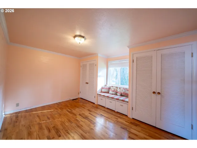 a view of empty room with wooden floor