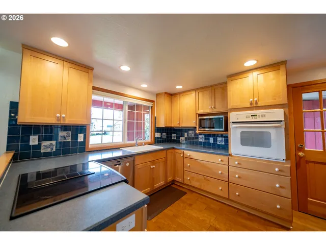 a kitchen with granite countertop a stove and cabinets
