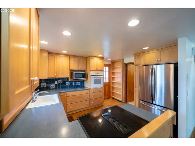 a living room with stainless steel appliances kitchen island furniture and a view of kitchen