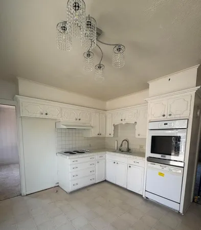 a utility room with cabinets washer and dryer