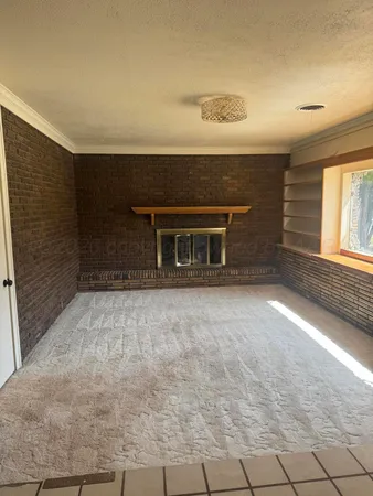 a view of empty room with a fireplace