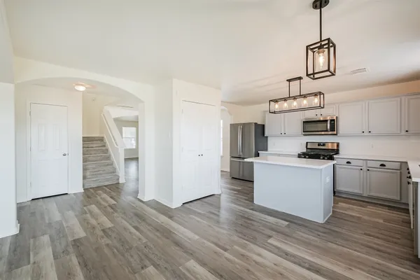 a kitchen with a refrigerator and white cabinets