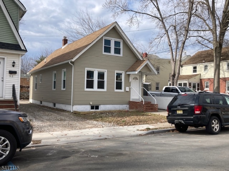 a black car in front of white house