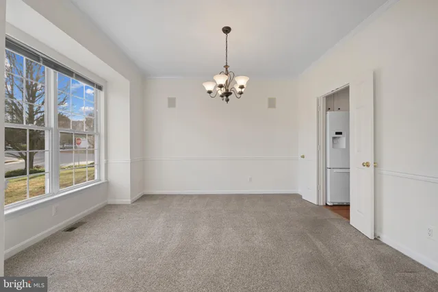 a view of a livingroom with wooden floor and a chandelier