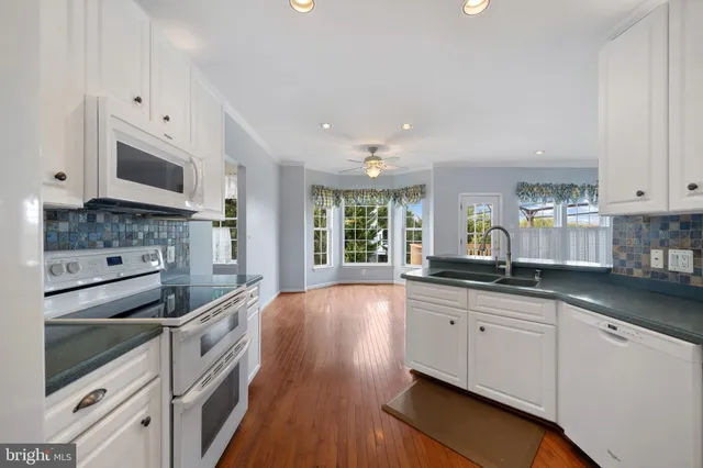 a kitchen with white cabinets and white appliances