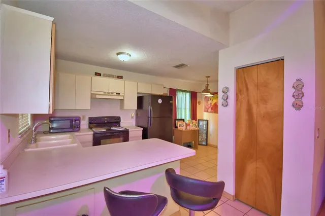 a kitchen with stainless steel appliances kitchen island granite countertop a refrigerator a stove a sink dishwasher with a dining table and chairs