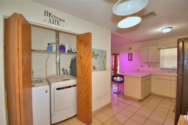 a utility room with cabinets dryer and washer