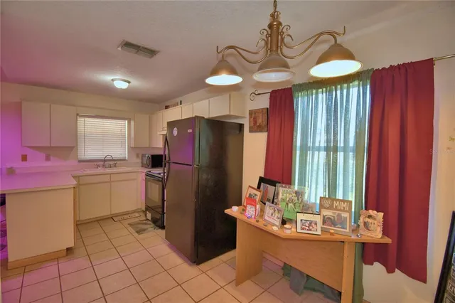 a kitchen with refrigerator and cabinets