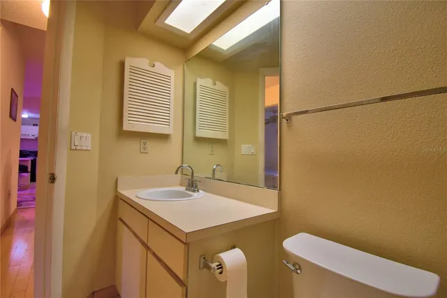 a bathroom with a sink a toilet a mirror and shower