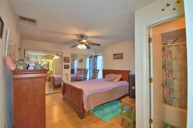 a bedroom with a bed and wooden floor