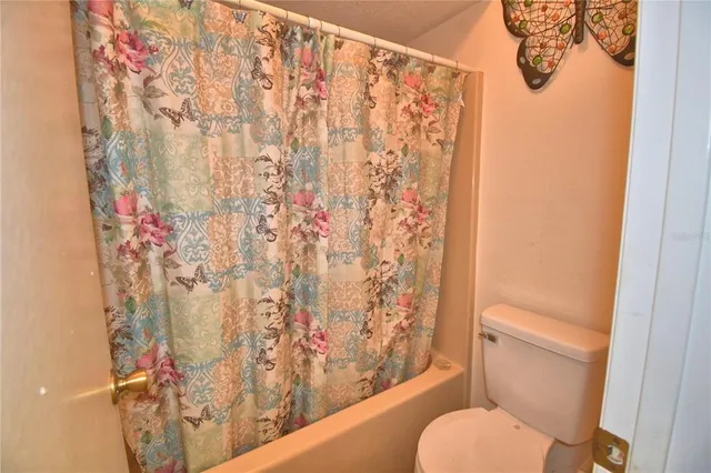a white toilet sitting next to a shower curtain