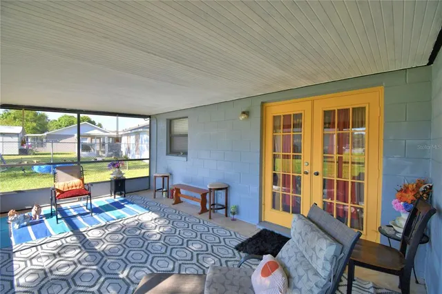 a living room with furniture and a floor to ceiling window
