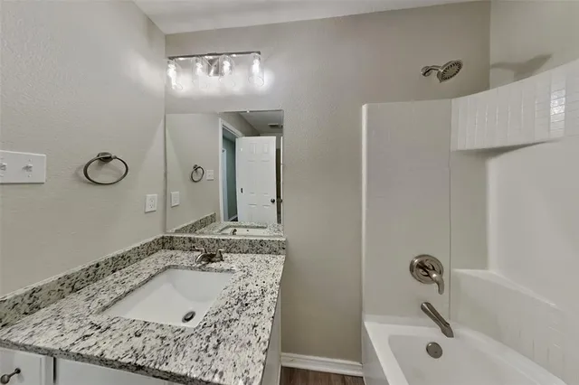 a bathroom with a tub sink and mirror