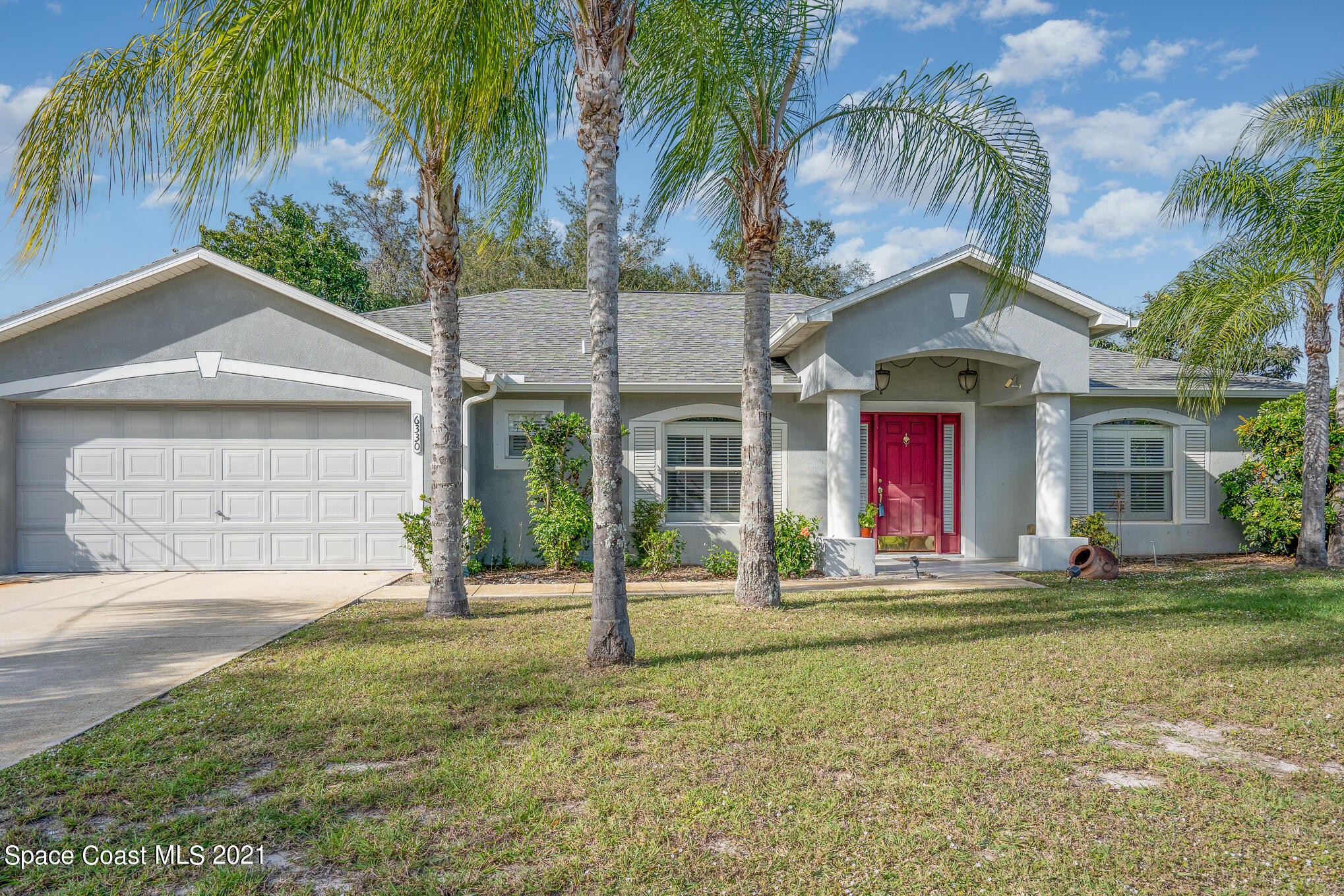 6330 Irving Road Cocoa, FL 32927 - Photo 1 of 22 a front view of a house with a yard and garage