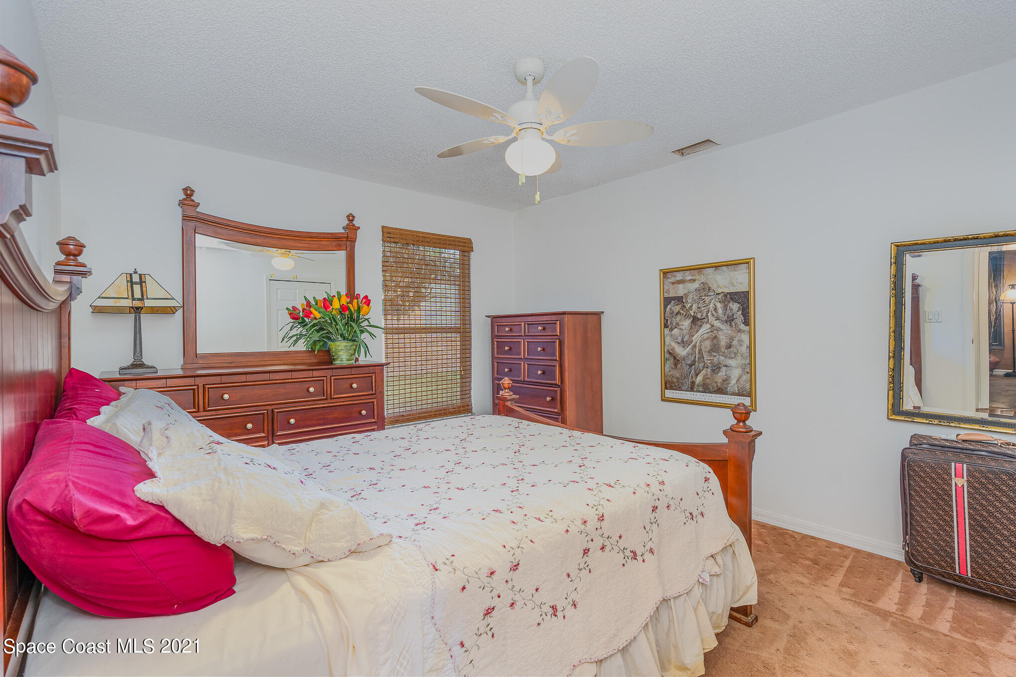 6330 Irving Road Cocoa, FL 32927 - Photo 14 of 22 a bedroom with a large bed and a chandelier