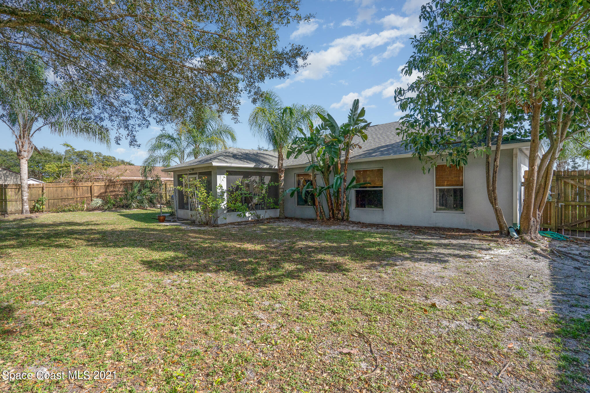 6330 Irving Road Cocoa, FL 32927 - Photo 21 of 22 a backyard of a house with table and chairs under an umbrella