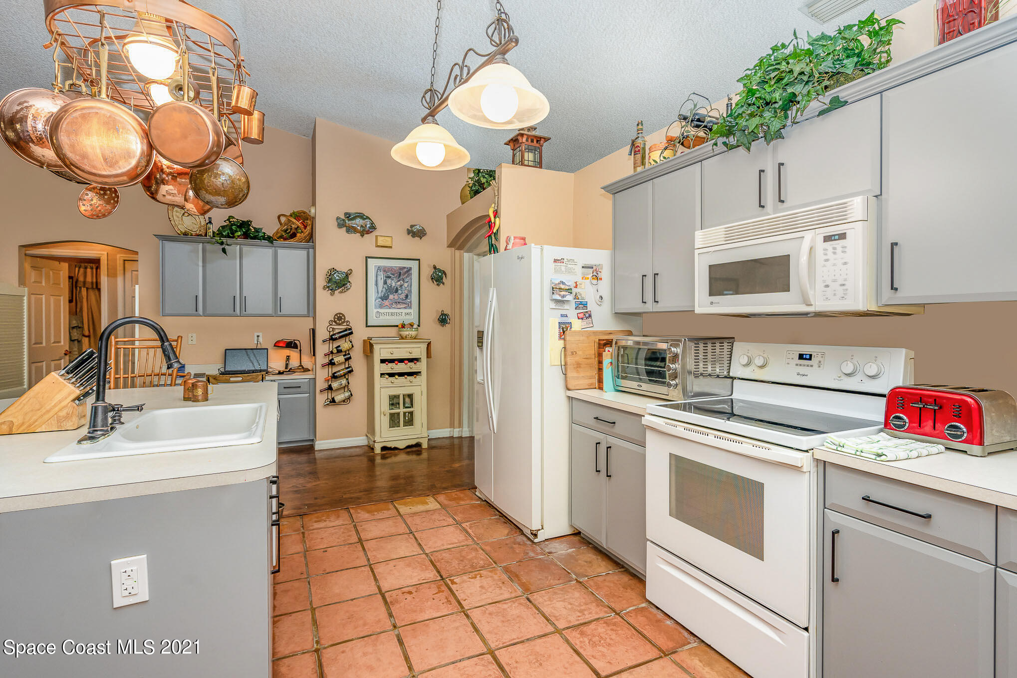 6330 Irving Road Cocoa, FL 32927 - Photo 7 of 22 a kitchen with a white cabinets and white appliances