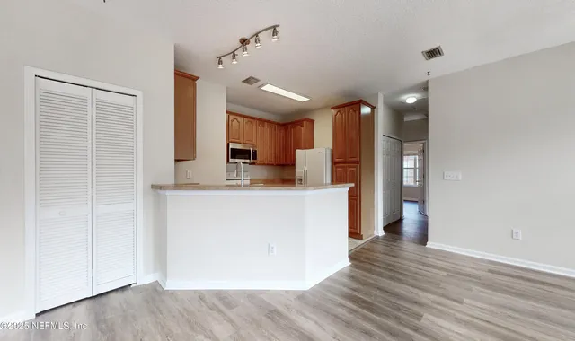 a kitchen with kitchen island a sink stainless steel appliances and cabinets
