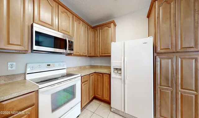 a kitchen with stainless steel appliances white cabinets white stove and a refrigerator